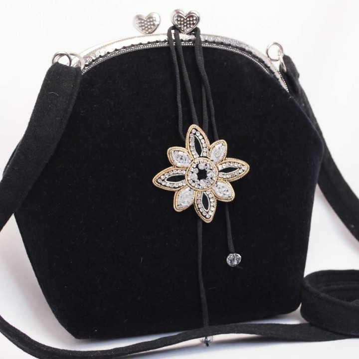 Borsa in velluto con ciondolo decorativo ricamato.